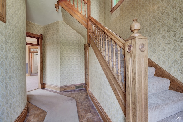 staircase featuring parquet flooring