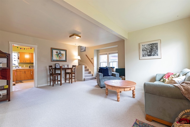 carpeted living room with beamed ceiling