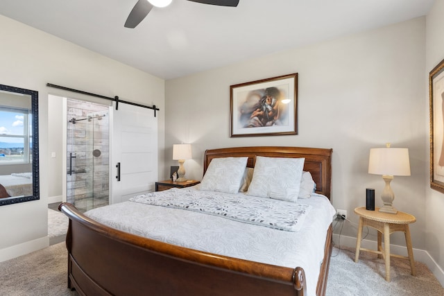 bedroom with ceiling fan, a barn door, and light carpet