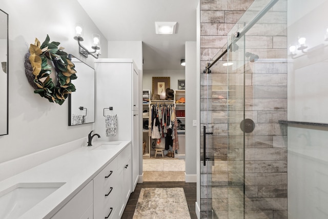 bathroom featuring hardwood / wood-style floors, vanity, and a shower with shower door