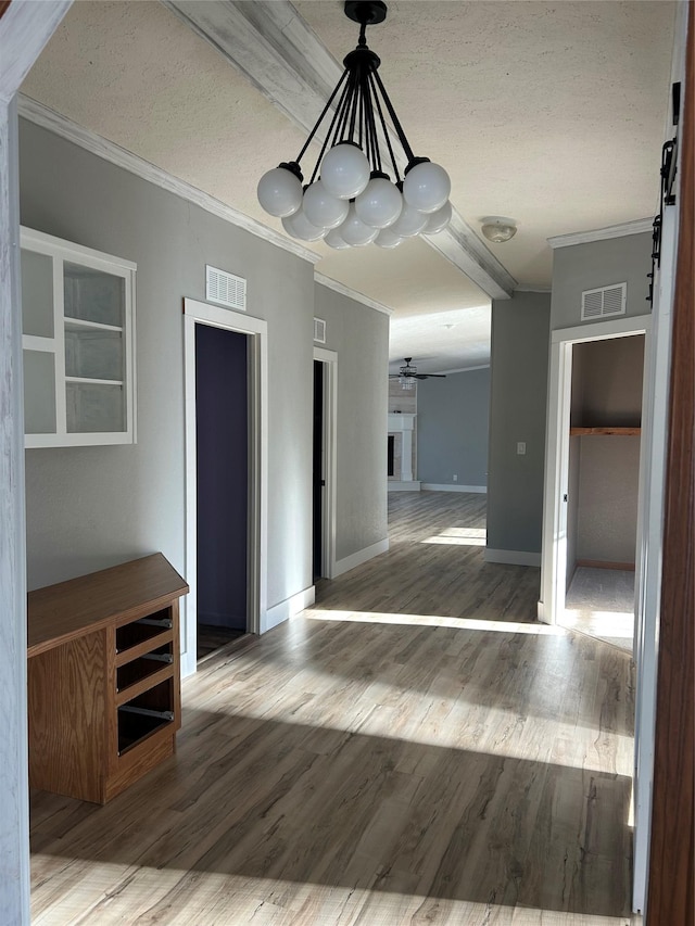 unfurnished dining area with ceiling fan, hardwood / wood-style floors, crown molding, and a textured ceiling