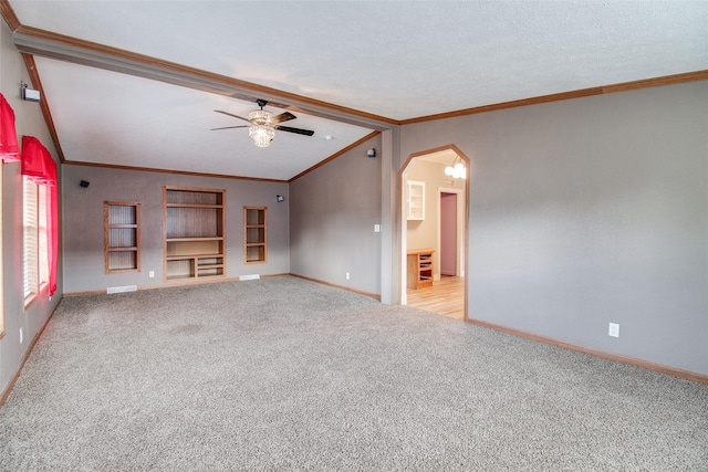 unfurnished living room with a textured ceiling, light carpet, built in features, ornamental molding, and ceiling fan