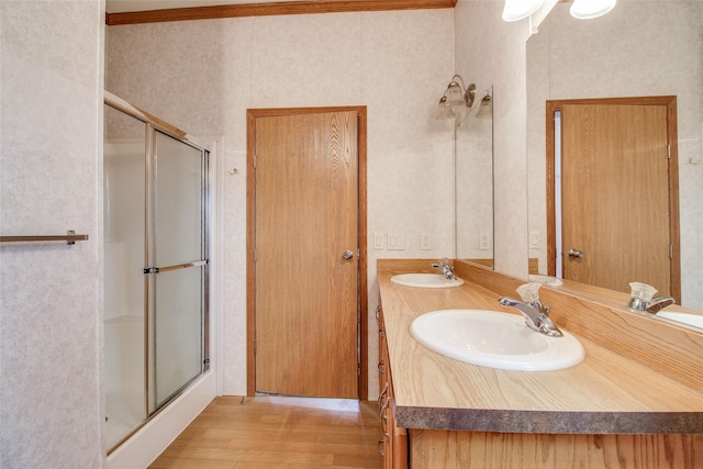 bathroom featuring vanity, ornamental molding, hardwood / wood-style floors, and an enclosed shower