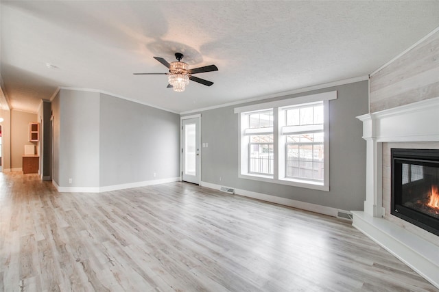 unfurnished living room featuring ceiling fan, crown molding, a textured ceiling, and light hardwood / wood-style floors