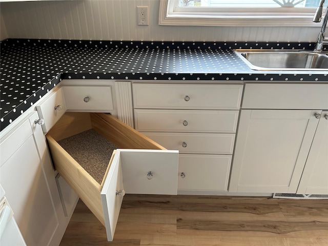 kitchen featuring sink, white cabinets, and light hardwood / wood-style flooring