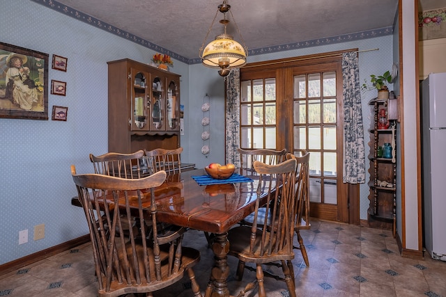 dining space featuring a textured ceiling and french doors