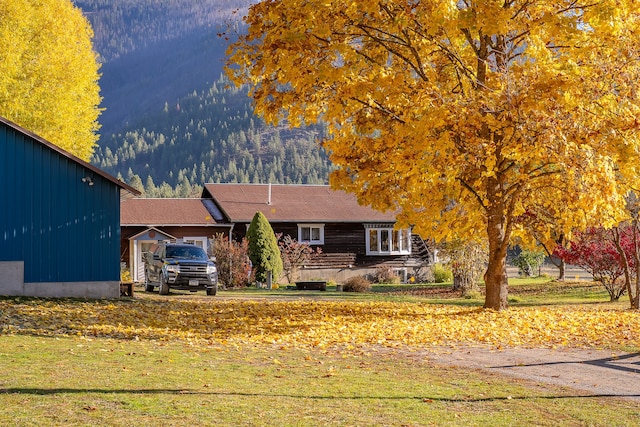 view of front of home with a mountain view and a front yard