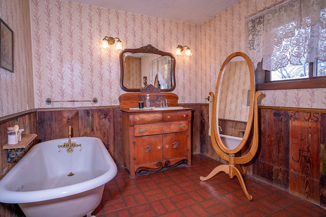 bathroom featuring wooden walls, a bathtub, and vanity