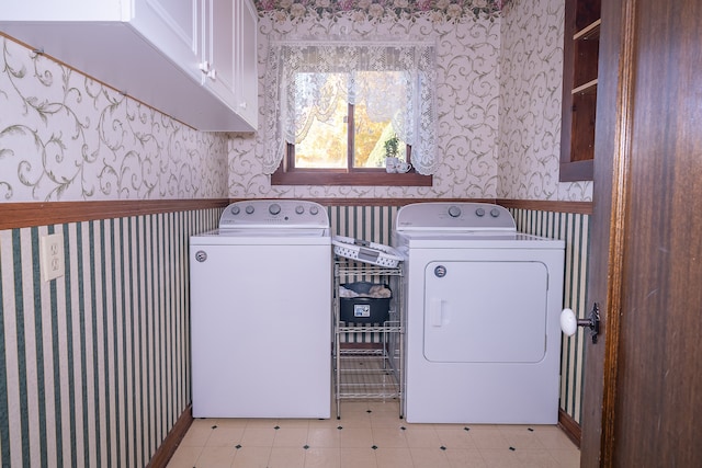 clothes washing area with cabinets and independent washer and dryer