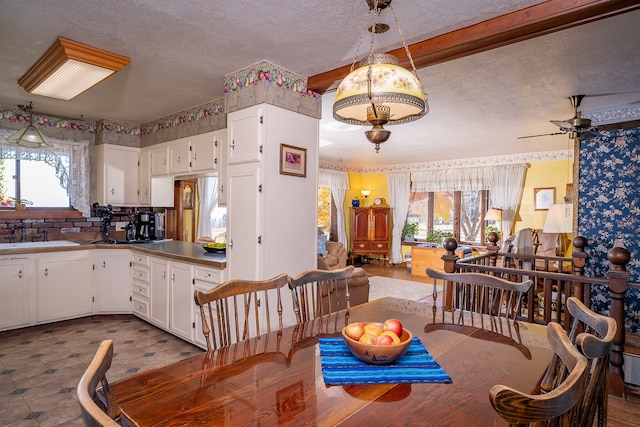 dining space with a wealth of natural light, sink, beamed ceiling, and ceiling fan