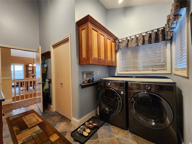 laundry area with cabinets, a high ceiling, and washing machine and clothes dryer