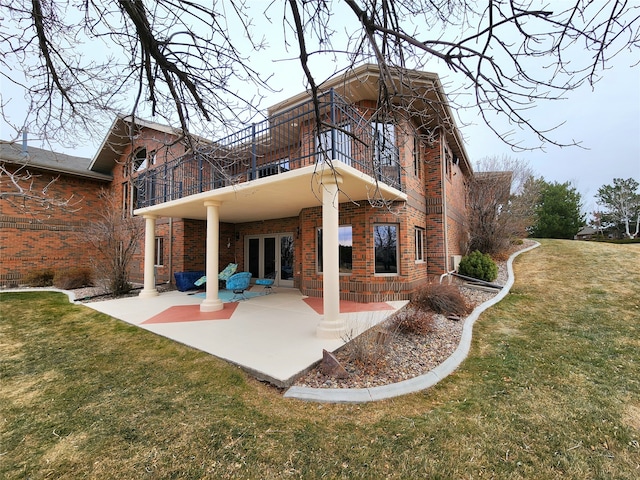 back of house with a balcony, a yard, and a patio