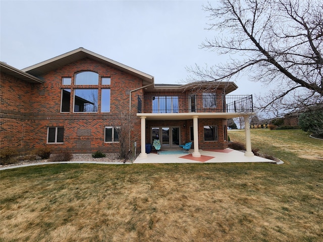 rear view of property with a lawn, a patio area, and a balcony