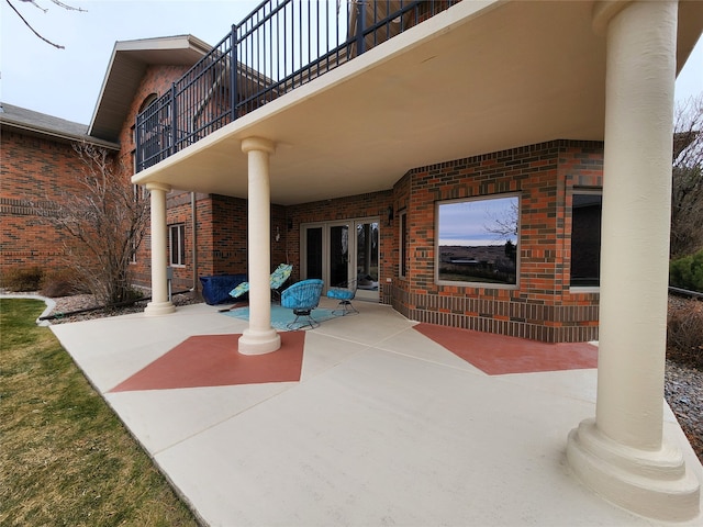 view of patio with a balcony and french doors