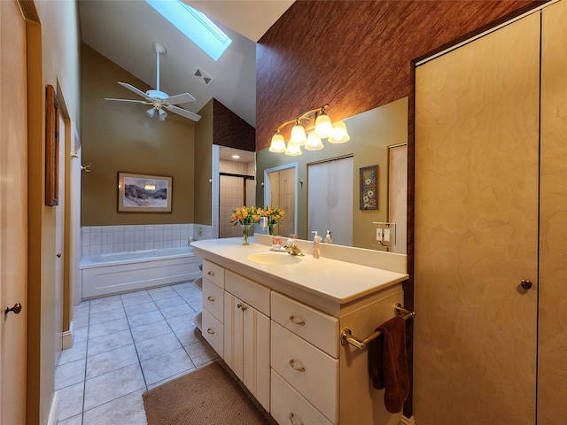 bathroom featuring vanity, a skylight, tile patterned flooring, a washtub, and ceiling fan