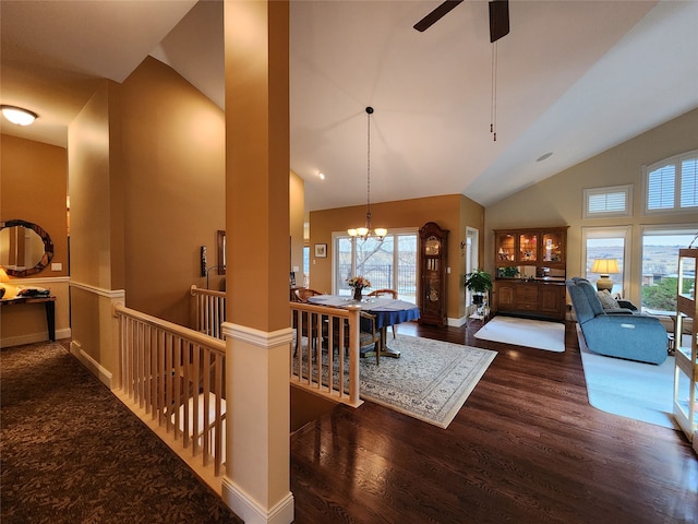 interior space with ceiling fan with notable chandelier, dark hardwood / wood-style flooring, and high vaulted ceiling