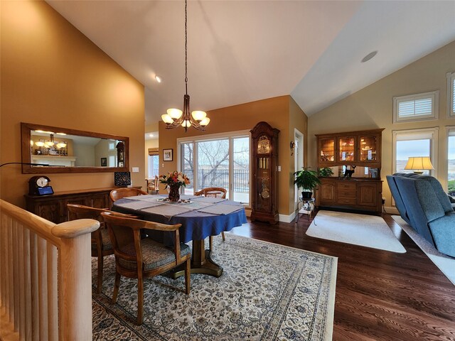 dining room with dark hardwood / wood-style flooring, an inviting chandelier, and high vaulted ceiling