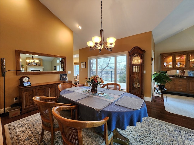 dining area featuring dark hardwood / wood-style floors, high vaulted ceiling, and an inviting chandelier