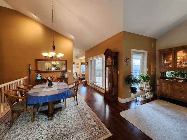 dining room with high vaulted ceiling, dark wood-type flooring, and a notable chandelier