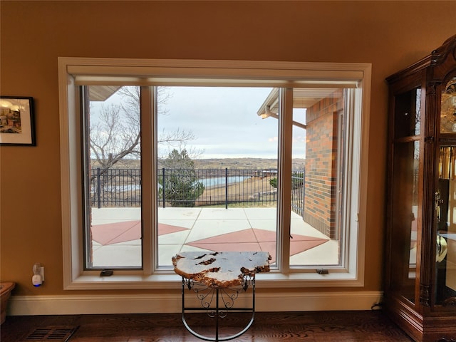 doorway featuring a water view and dark hardwood / wood-style floors