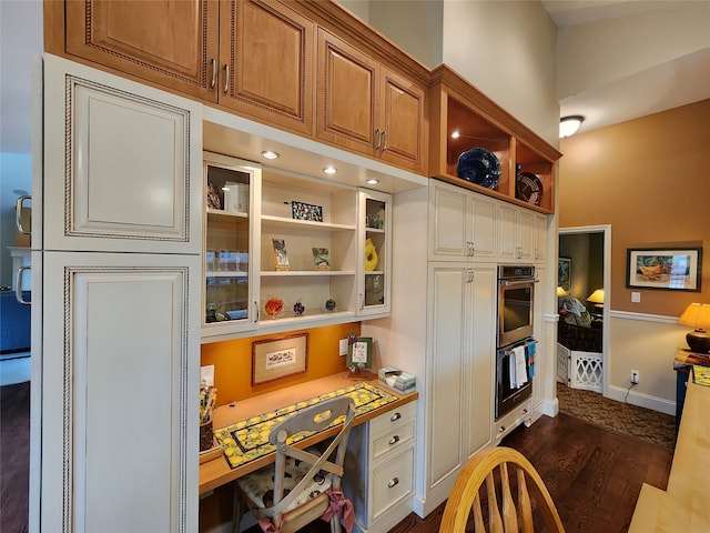 kitchen featuring stainless steel double oven and dark wood-type flooring