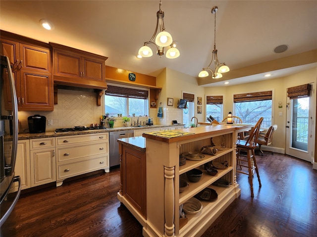 kitchen featuring pendant lighting, dark wood-type flooring, plenty of natural light, and a notable chandelier