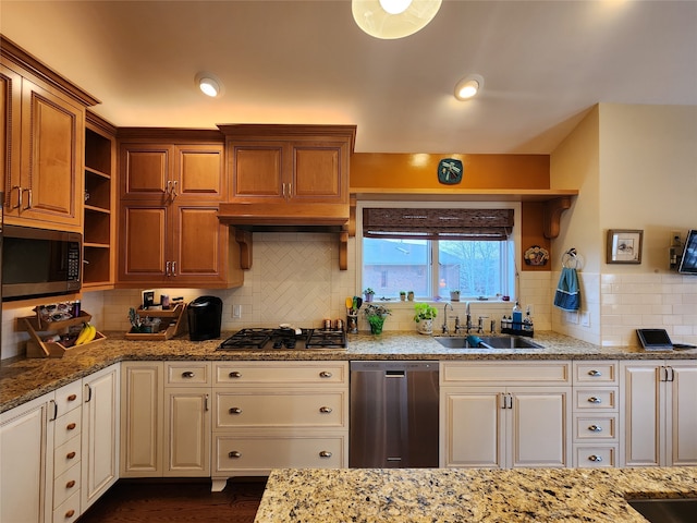 kitchen featuring sink, light stone countertops, stainless steel appliances, and tasteful backsplash