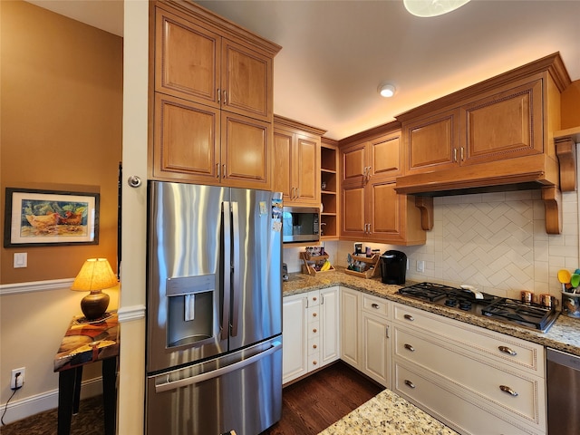 kitchen with backsplash, light stone counters, stainless steel appliances, and dark wood-type flooring