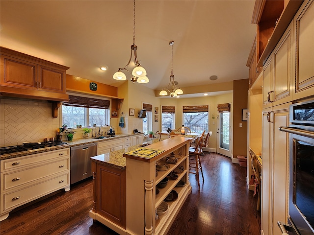 kitchen with dark hardwood / wood-style flooring, stainless steel appliances, sink, pendant lighting, and a chandelier