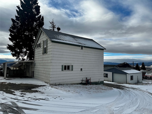 snow covered property with a garage