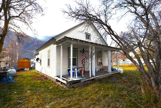 view of front facade with covered porch and a storage shed