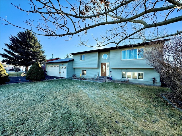 bi-level home featuring a garage and a front lawn