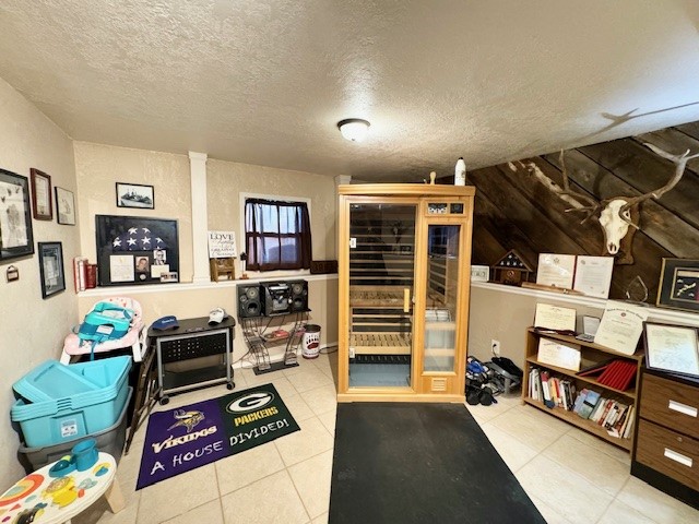 interior space with light tile patterned floors and a textured ceiling