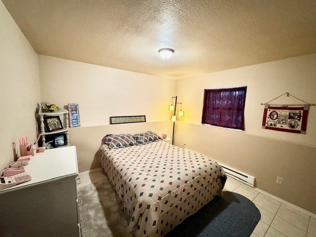 tiled bedroom featuring a baseboard radiator and a textured ceiling