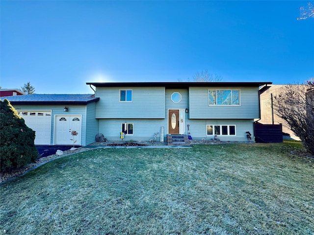 split foyer home featuring a garage and a front yard