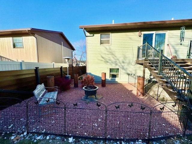 rear view of property with an outdoor fire pit