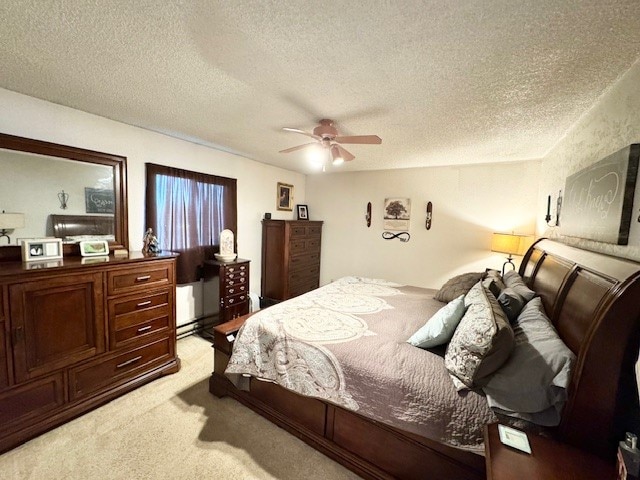 bedroom featuring ceiling fan, light carpet, and a textured ceiling