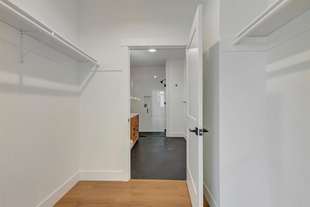 walk in closet with wood finished floors