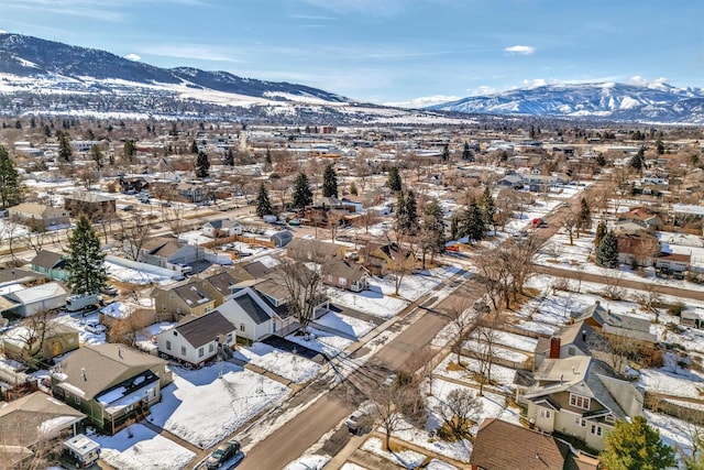 snowy aerial view with a residential view and a mountain view