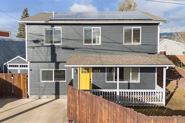 view of front of home with covered porch and solar panels