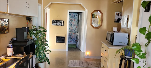 hallway featuring concrete floors and heating unit