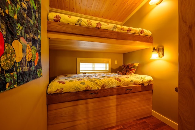 bedroom with hardwood / wood-style floors, wooden ceiling, and crown molding