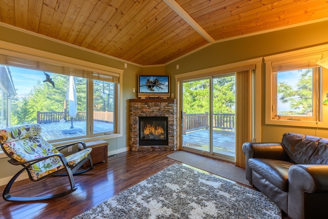 living room featuring wooden ceiling, dark wood-type flooring, a stone fireplace, vaulted ceiling, and ornamental molding