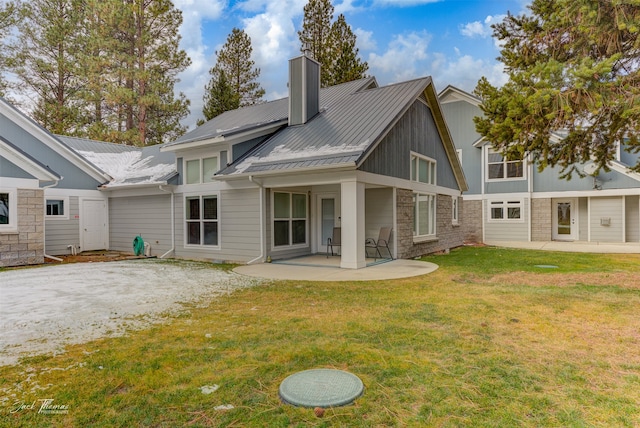 back of property with a yard and a patio