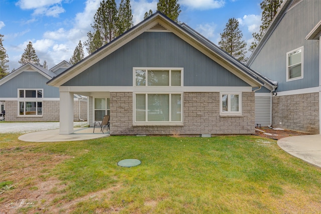 rear view of property featuring a patio and a lawn