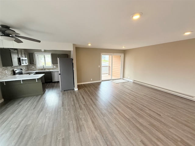 kitchen featuring wood-type flooring, stainless steel appliances, a healthy amount of sunlight, and sink