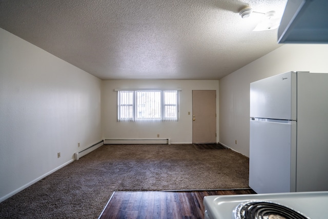 kitchen with dark colored carpet, white fridge, and a textured ceiling