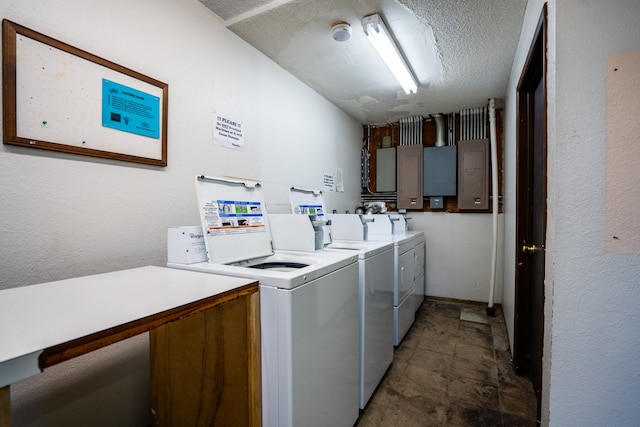 laundry room featuring washer and dryer, a textured ceiling, and electric panel