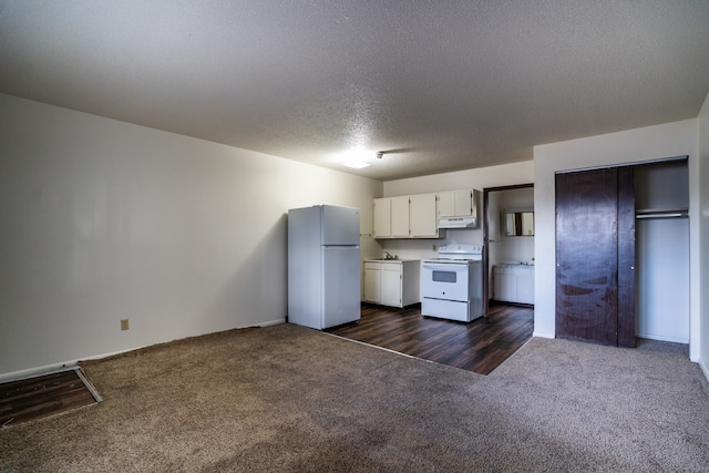 kitchen featuring dark hardwood / wood-style flooring, white appliances, a textured ceiling, and white cabinetry