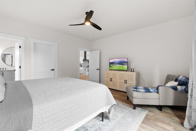 bedroom featuring ensuite bath, ceiling fan, and light wood-type flooring